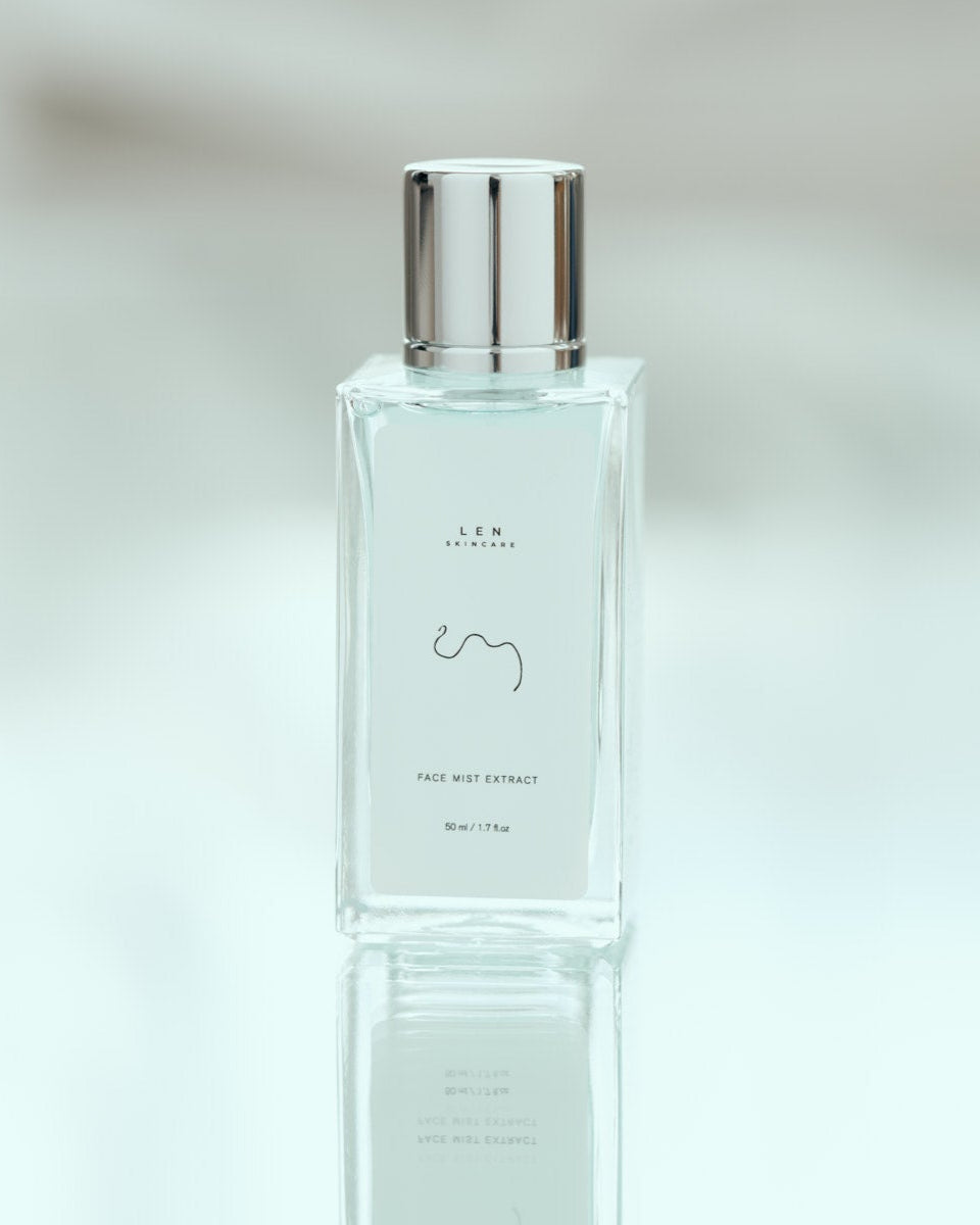 Clear bottle with silver cap on a reflective surface