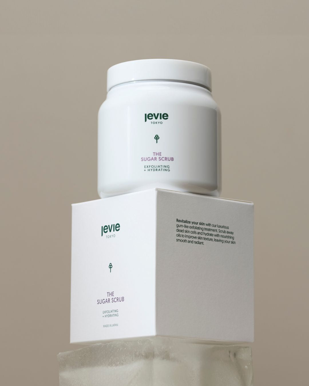 Jevie sugar scrub container and packaging on a beige background