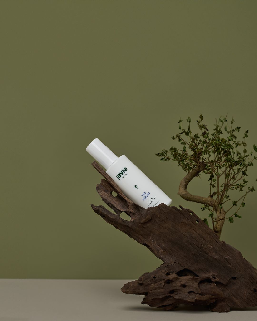 White bottle with a label on a wooden surface against a green background