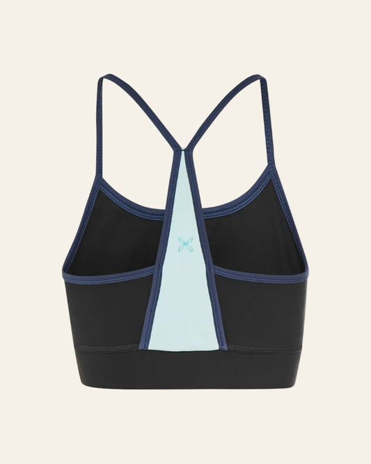 Black sports bra with blue accents on a beige background 