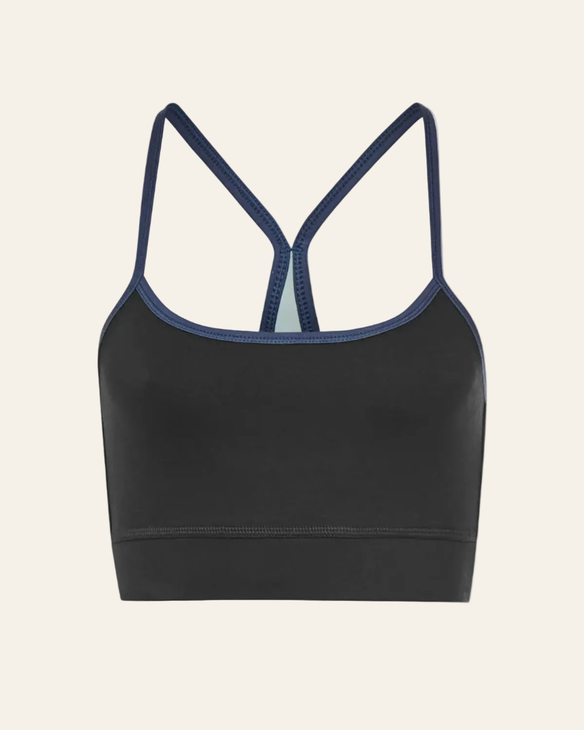 Black sports bra with thin straps on a beige background