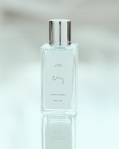 Clear bottle with silver cap on a reflective surface