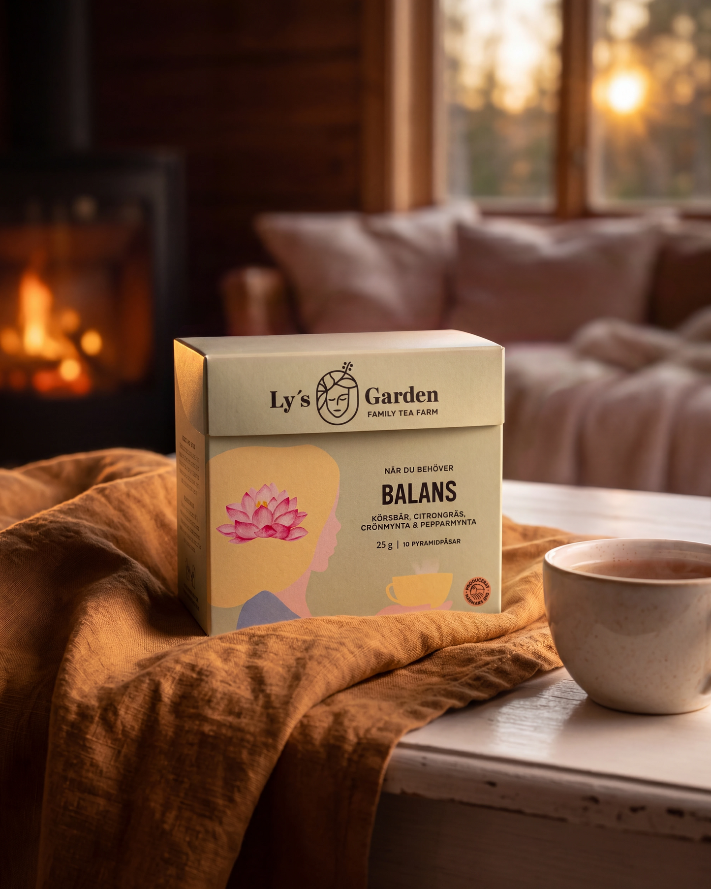 Box of 'Ly's Garden Balans' tea on a table with a cup of tea and a warm interior setting.