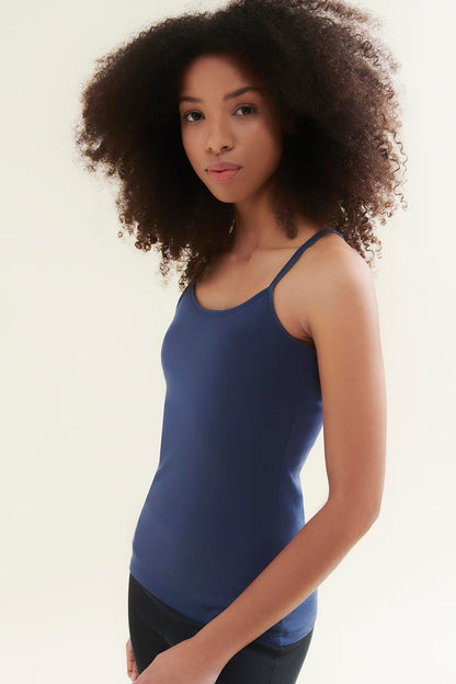 Woman wearing a blue tank top against a plain background